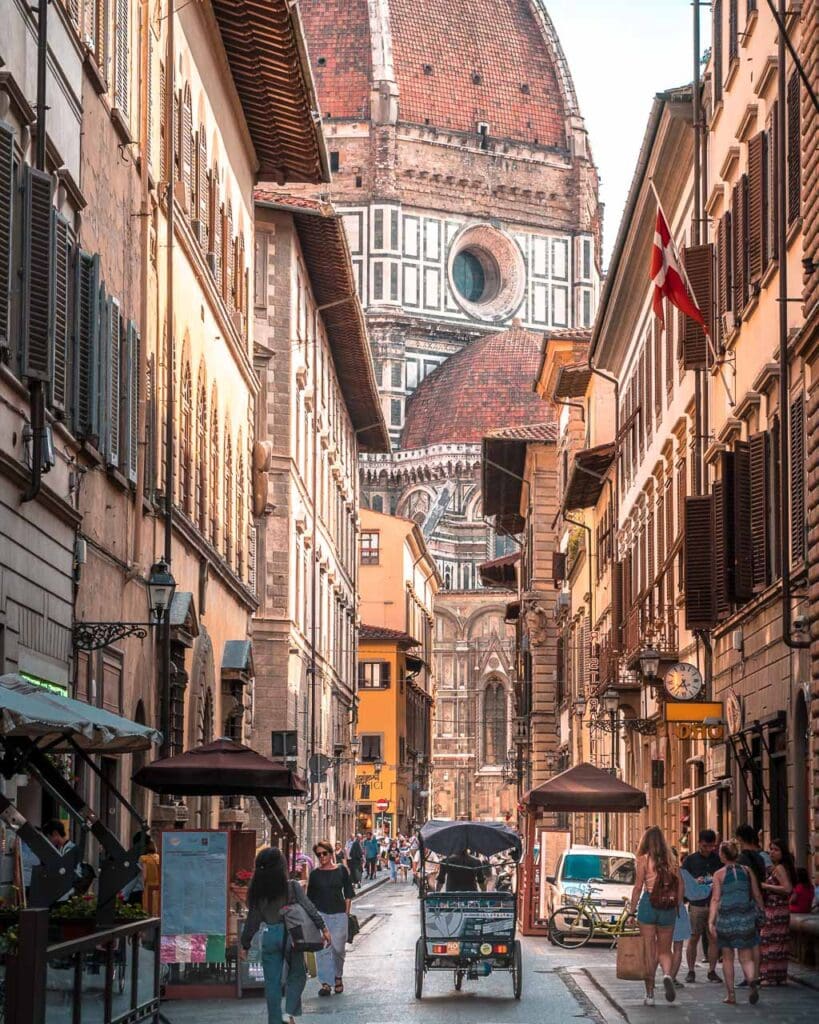 A street in Florence, Northern Italy, with the Florence Cathedral behind (Cattedrale di Santa Maria del Fiore - Duomo di Firenze).