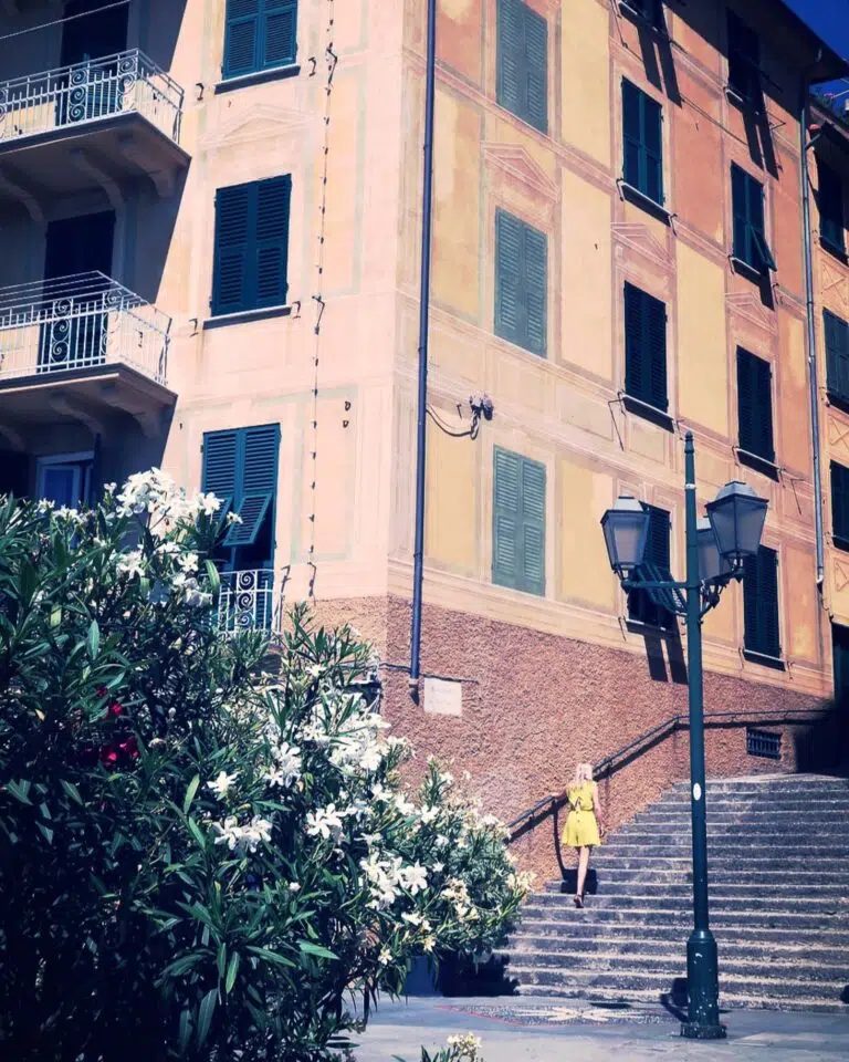 Woman in yellow dress walks up some steps in Santa Margherita Ligure, Northern Italy