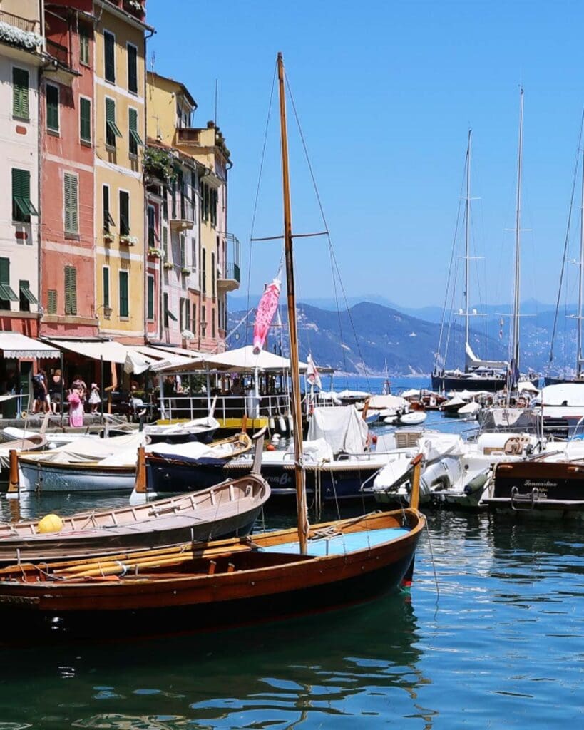 Boats at Portofino Harbour, Italy, lined with pastel coloured houses.
