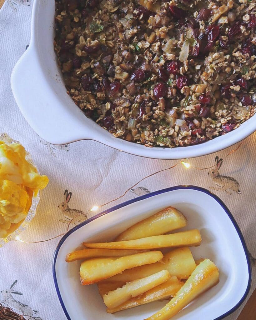 Maple roasted parsnips and chestnut and cranberry vegan stuffing in a dish on a Christmas table