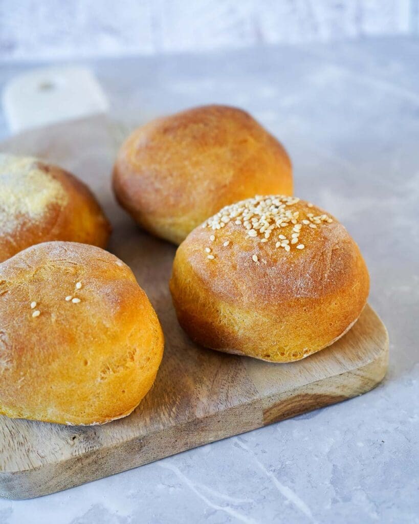 Beautiful orange sweet potato bread rolls on a wooden board