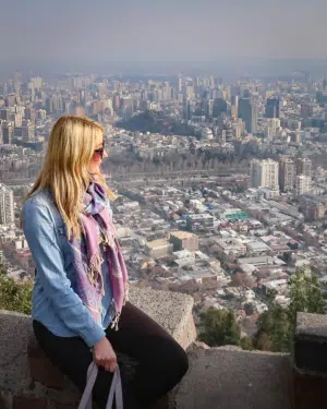 A blonde woman sat at the top of San Cristobal Hill in Santiago, Chile, overlooking the incredible view of the city