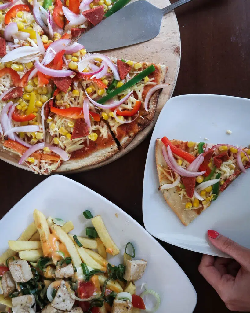 A colour fun vegan pizza and loaded fries from a vegan restaurant in Santiago, Chile