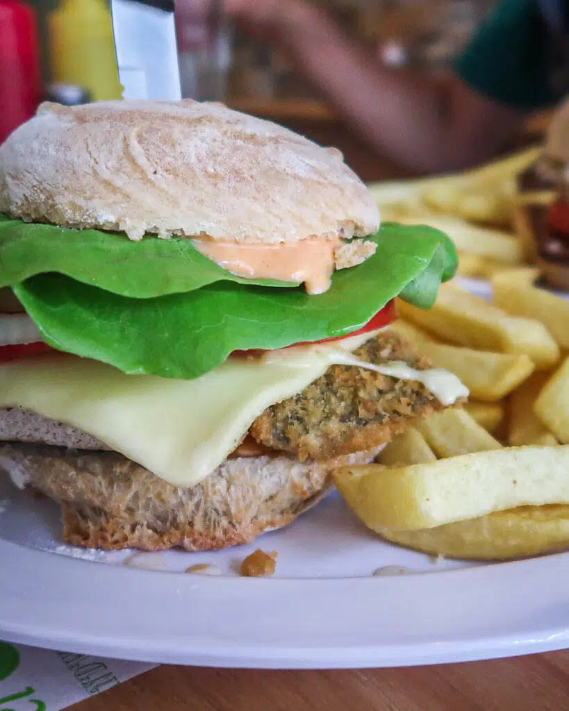 A vegan fillet-no-fish burger with a melty cheese slice, lettuce and fries from a vegan restaurant in Santiago