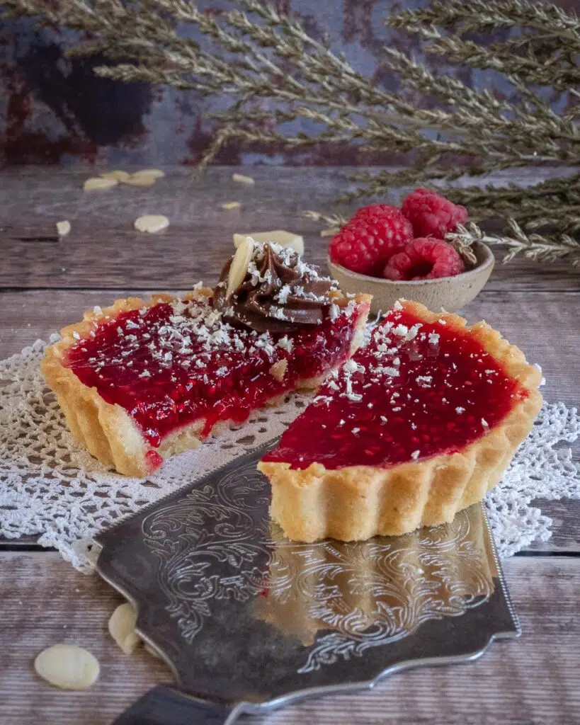 A raspberry vegan jam tart cut in half