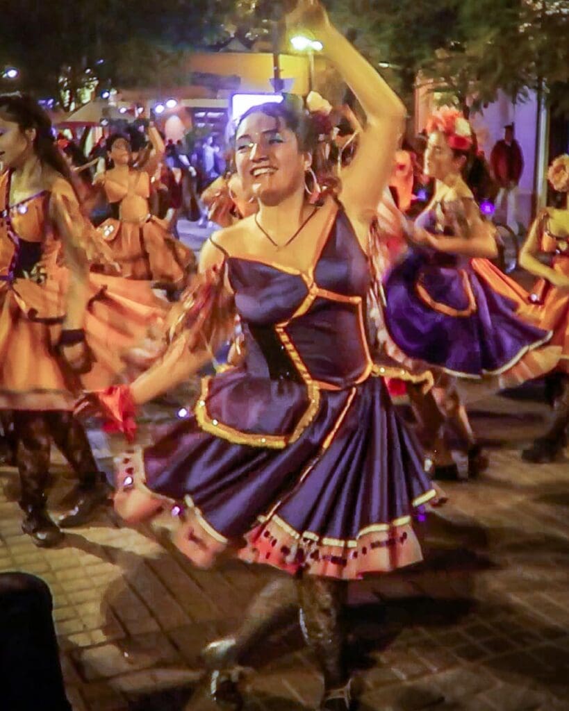 Street performers dancing and smiling during a street party in Santiago, Chile
