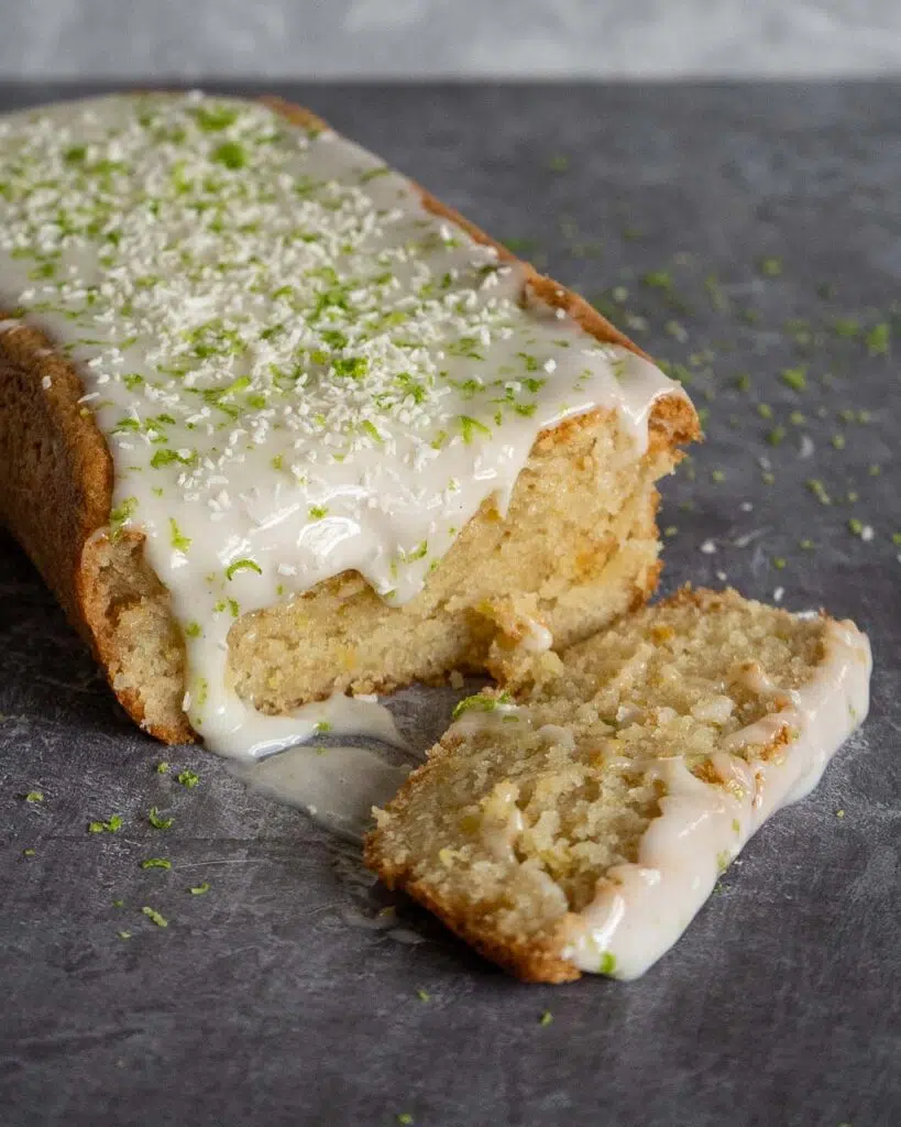 A lemon and yoghurt vegan loaf cake with icing and fresh lime zest