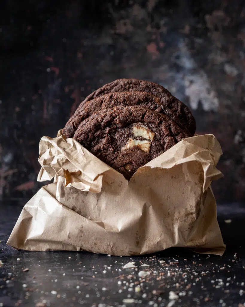 Vegan bakery style triple chocolate cookies in a paperbag