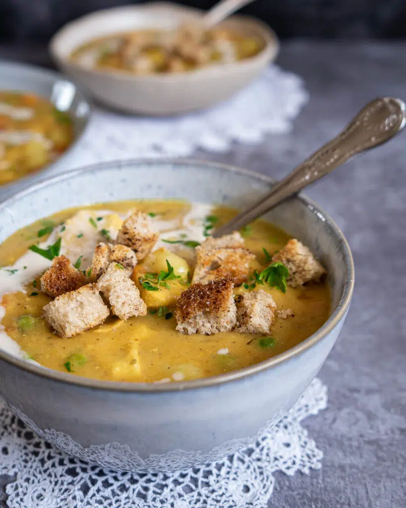 A bowl of creamy vegan chicken soup with crispy garlic croutons on top
