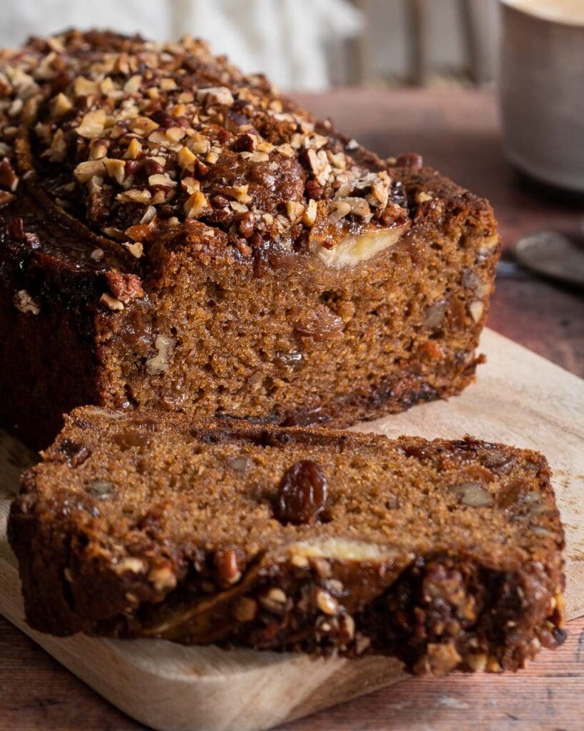 Vegan banana bread with a nutty crumble topping on a wooden board