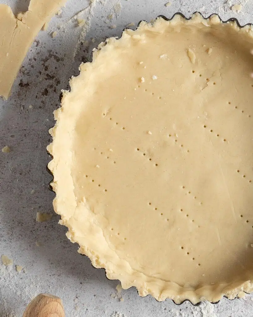 Close up of vegan shortcrust pastry lining a metal fluted baking tin
