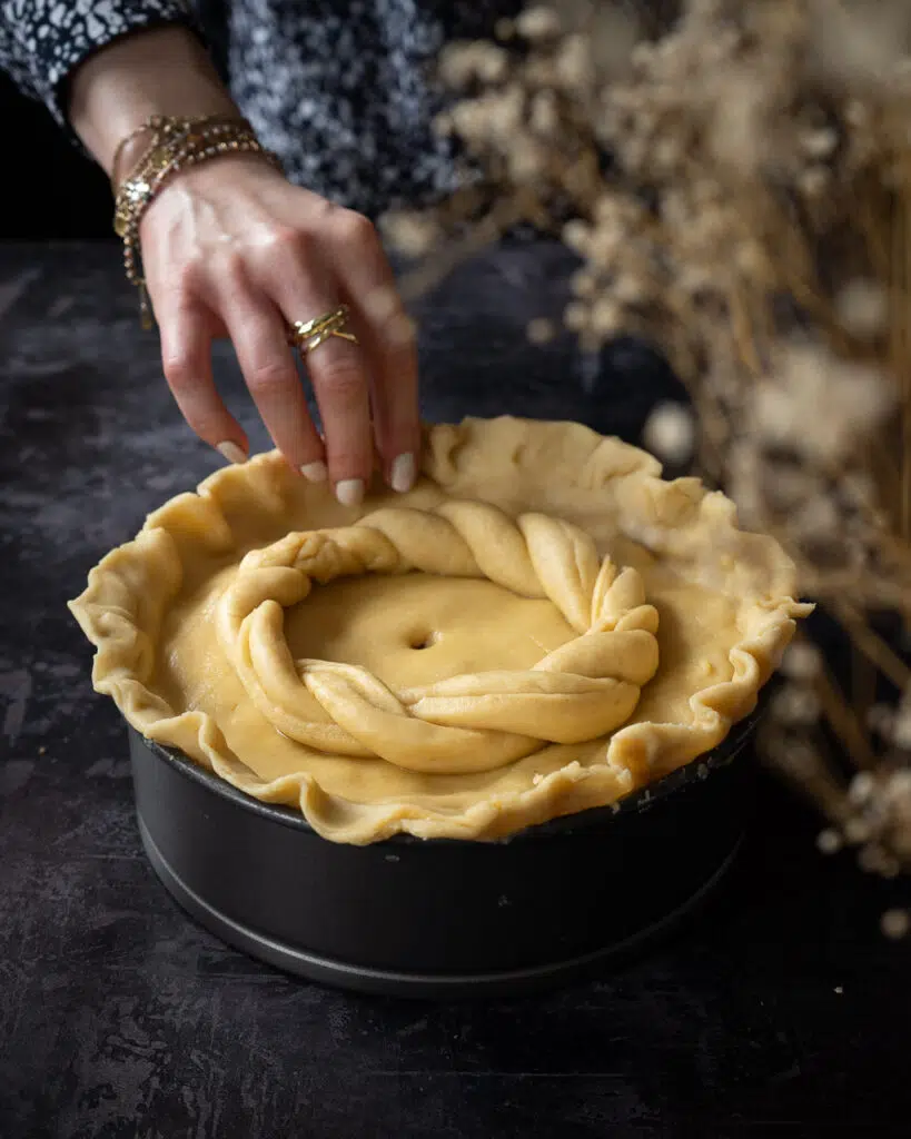 A woman shaping a vegan hot water crust pastry pie in a baking tin