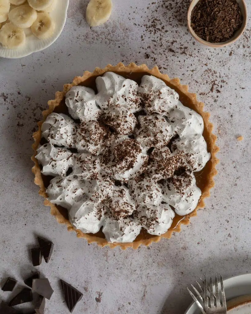 A whole vegan Banoffee Pie with piped whipped dairy free cream, photographed from above