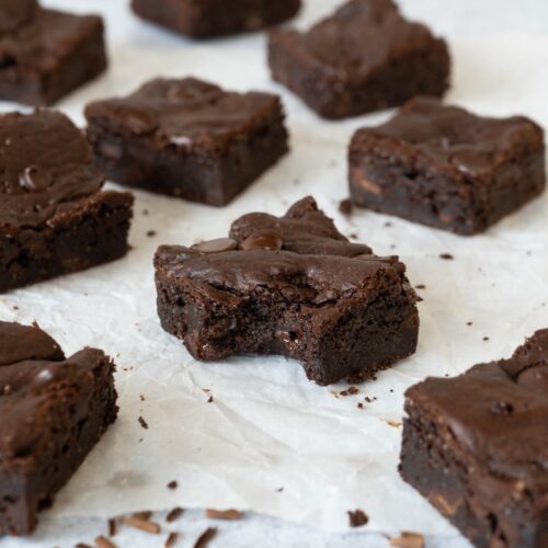 Squares of rich fudgey vegan chocolate brownie studded with dark chocolate chips