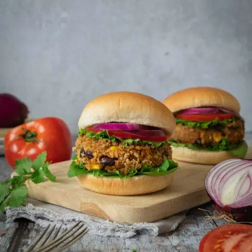 A BBQ bean burger in a soft bun, coated in a crispy breadcrumb coating and topped with lettuce, tomato and red onion.