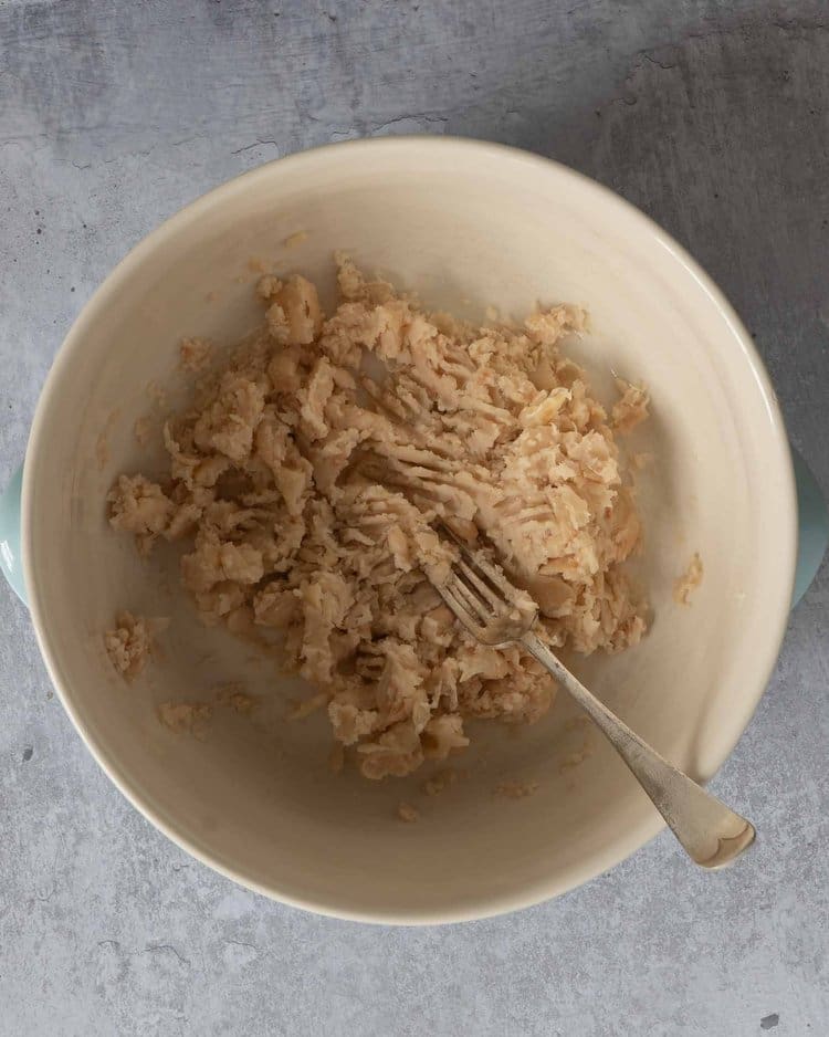 Mashed cannellini beans in a bowl