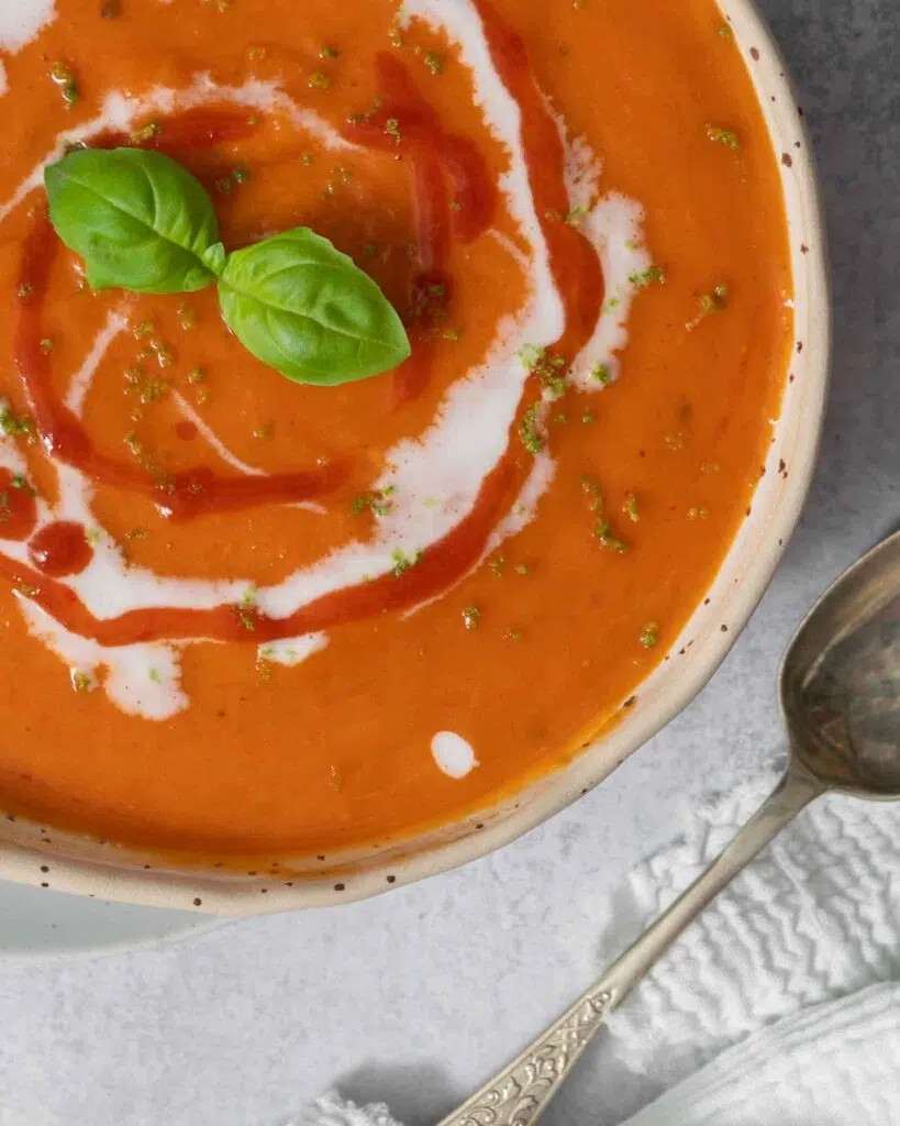 Rich butternut squash and roasted red pepper soup with swirls of coconut cream, sriracha chilli sauce, fresh basil and served with sourdough toast.
