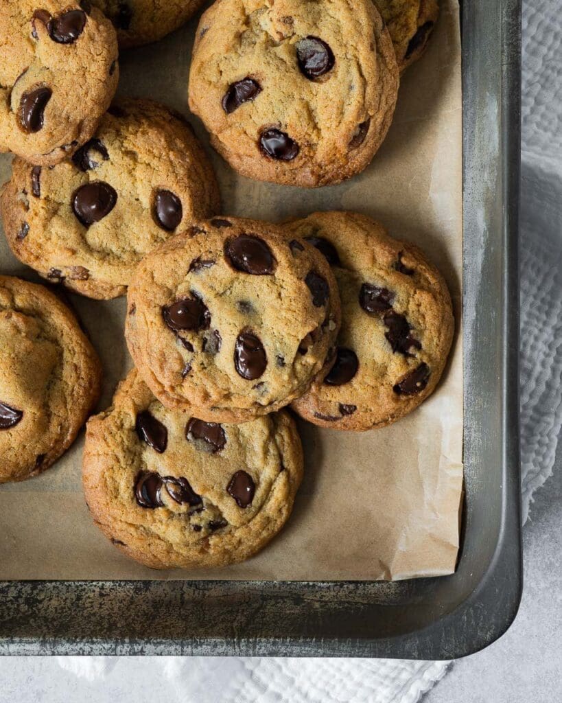 Deliciously soft and chewy vegan cookies fresh from the oven with melty chocolate chips and caramelised pecan pieces