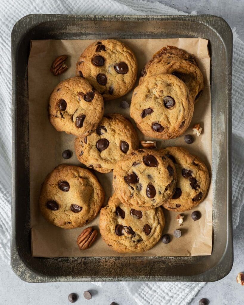 Deliciously soft and chewy vegan cookies fresh from the oven with melty chocolate chips and caramelised pecan pieces