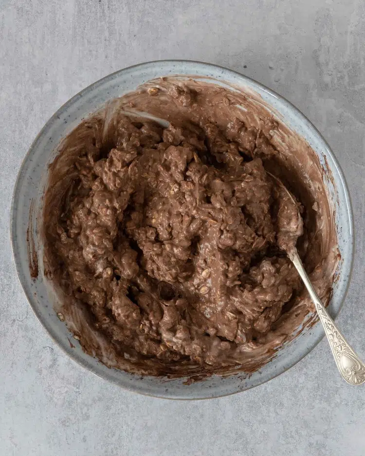 Chocolate peanut butter bircher being mixed up in a bowl ready for toppings to be added