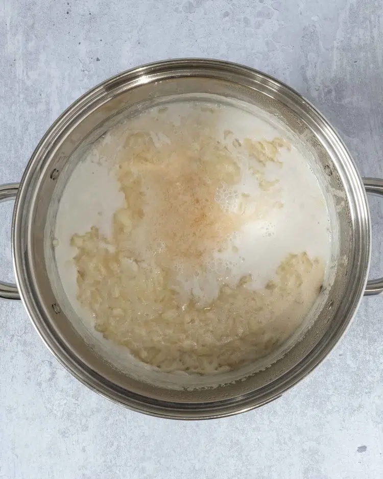 A saucepan filled with creamy coconut rice pudding, being brought to a simmer
