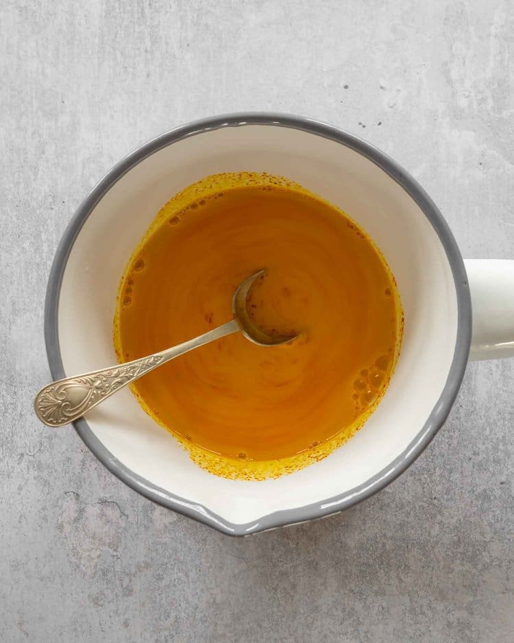 Golden saffron milk in a white saucepan
