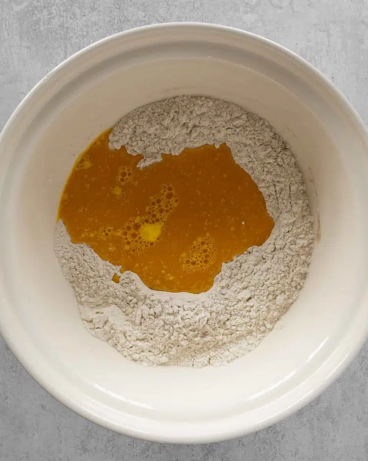 Flour and golden saffron milk in a large mixing bowl