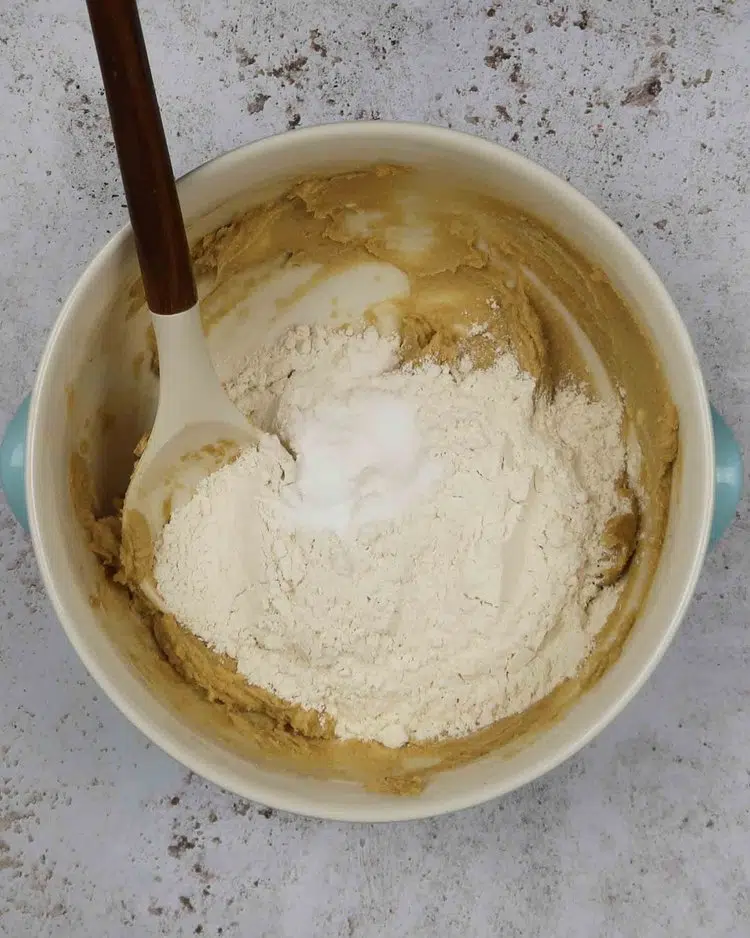 Creamed butter and sugar in a mixing bowl with flour on top