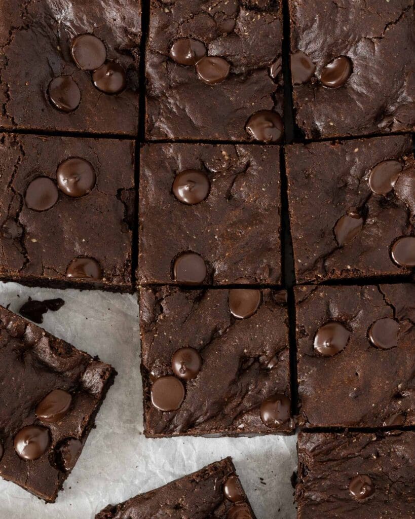 Squares of rich fudgey vegan chocolate brownie studded with dark chocolate chips