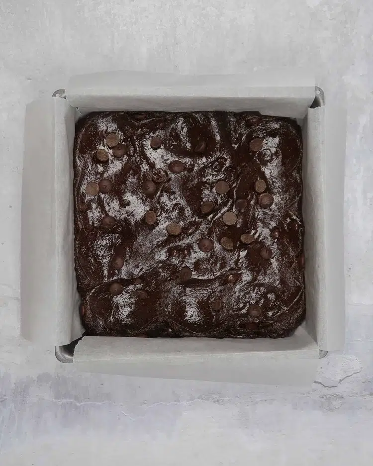 Add vegan chocolate brownie cake batter to a baking tin