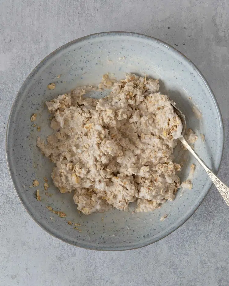 The oat and yoghurt base for Mango Colada Bircher in a bowl having just been stirred together