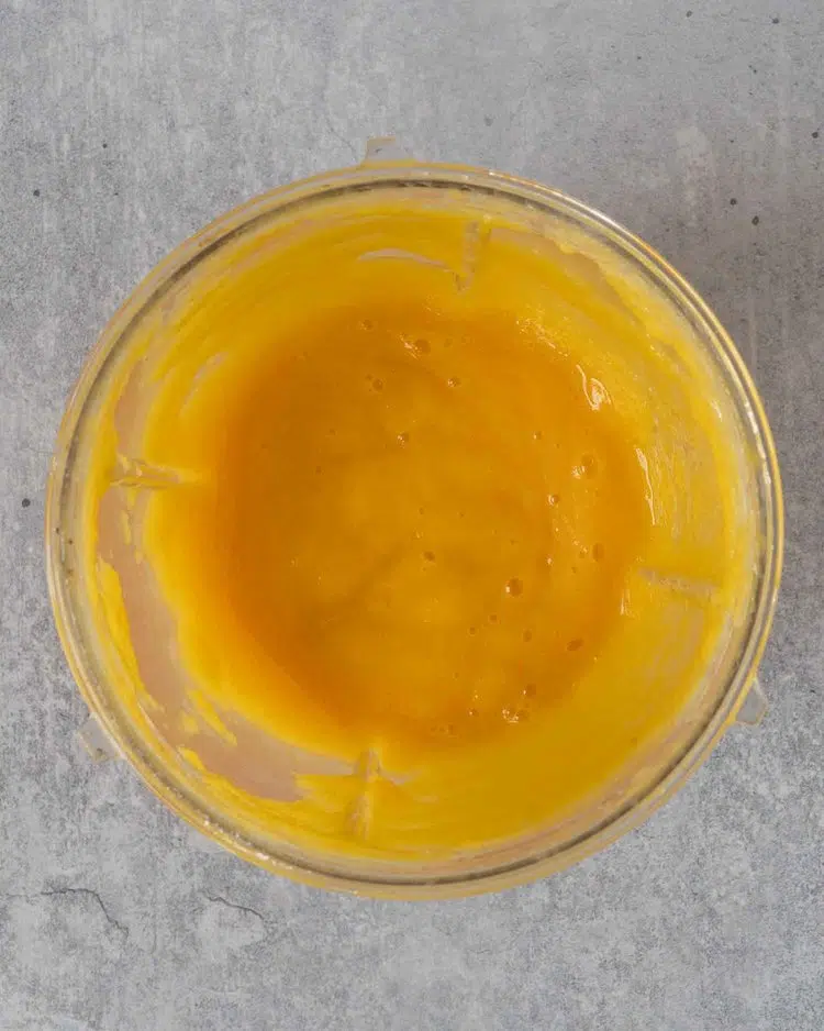 Freshly blended mango puree in a blender cup