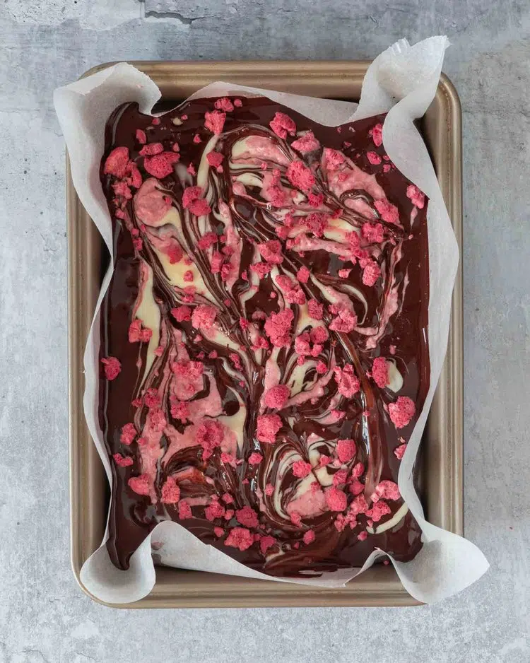 Melted dark chocolate, white chocolate and pink raspberry chocolate swirled together in a lined baking tin and topped with freeze dried raspberries
