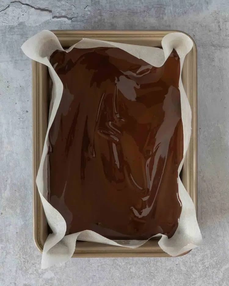 Melted dark chocolate in a lined brownie tin
