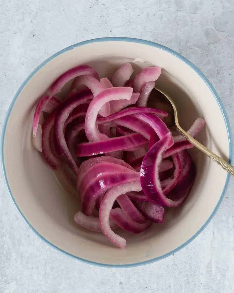 Sliced picked red onions in a bowl