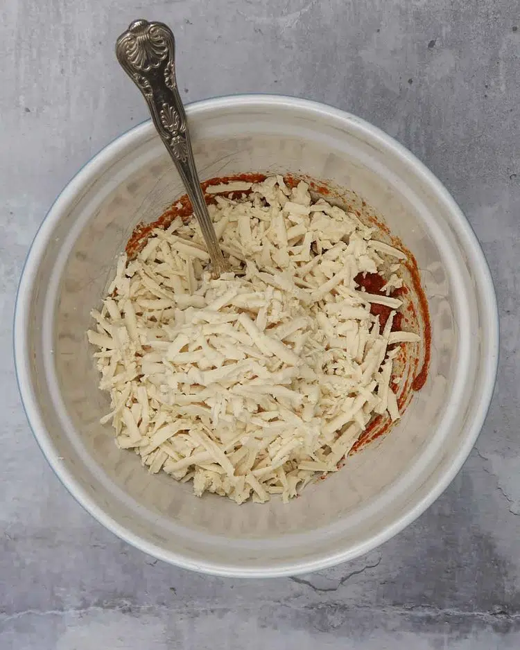 Grated tofu in a bowl ready to be stirred and coated in spices and olive oil