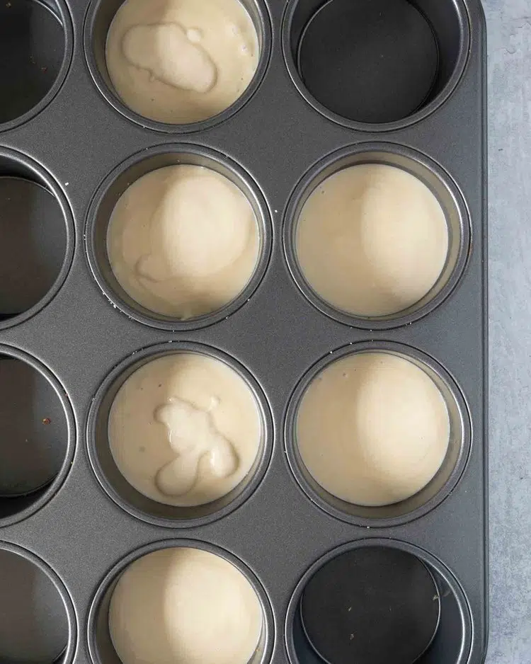 A muffin tin filled with individual mini cheesecakes