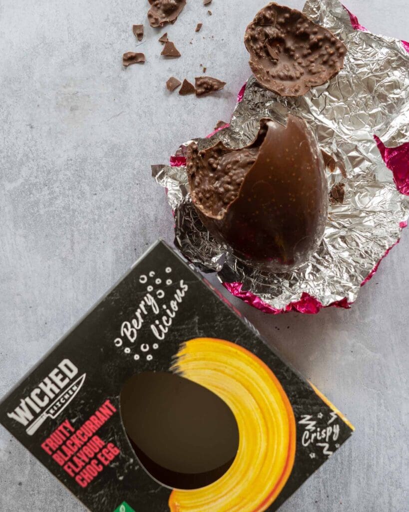 Wicked Kitchen Fruity Blackcurrant Easter egg broken open on a table top
