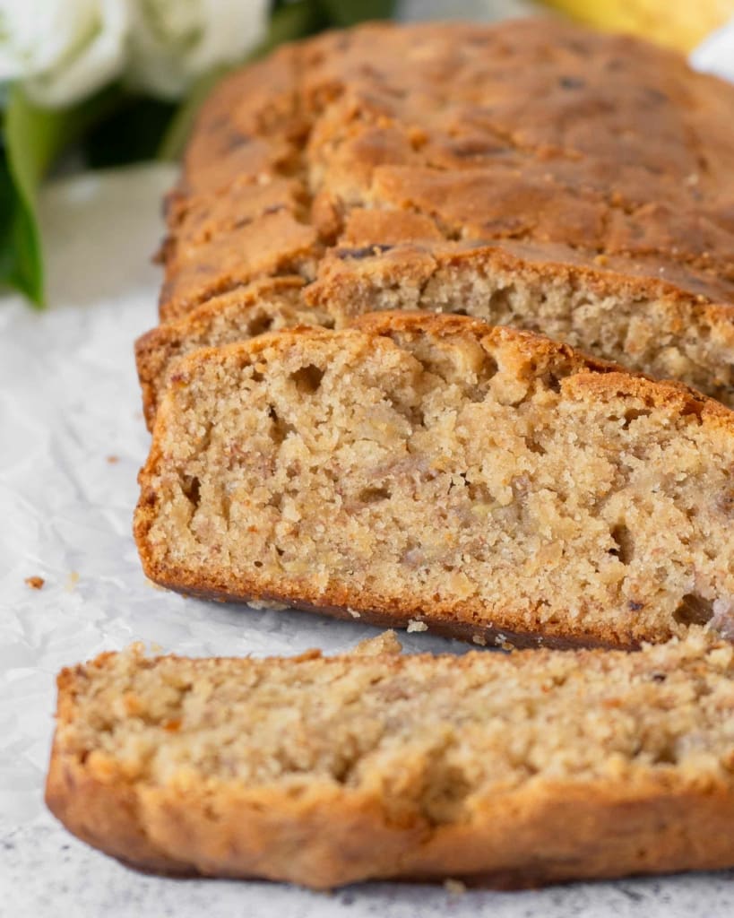 Slices of tender vegan banana bread, with a golden top and a moist centre