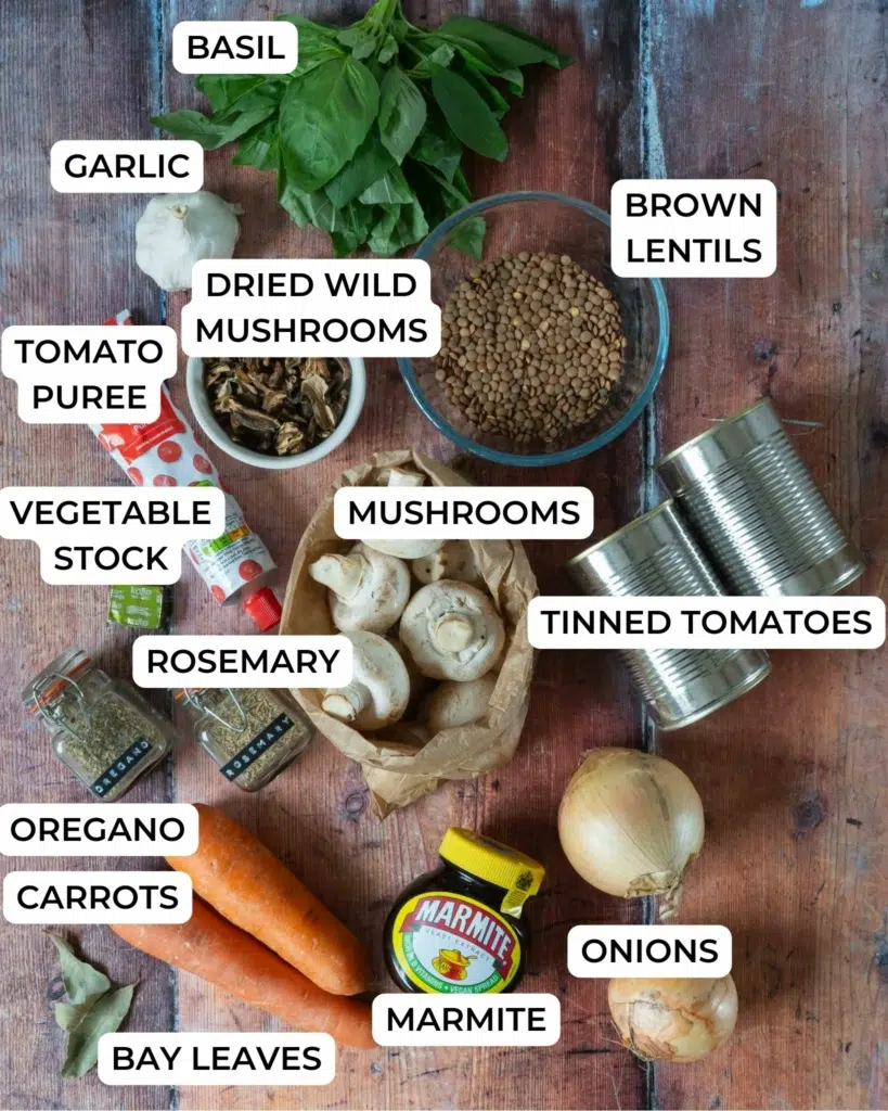 The ingredients needed to make vegan lentil and mushroom bolognese, laid out on a table top and labelled.