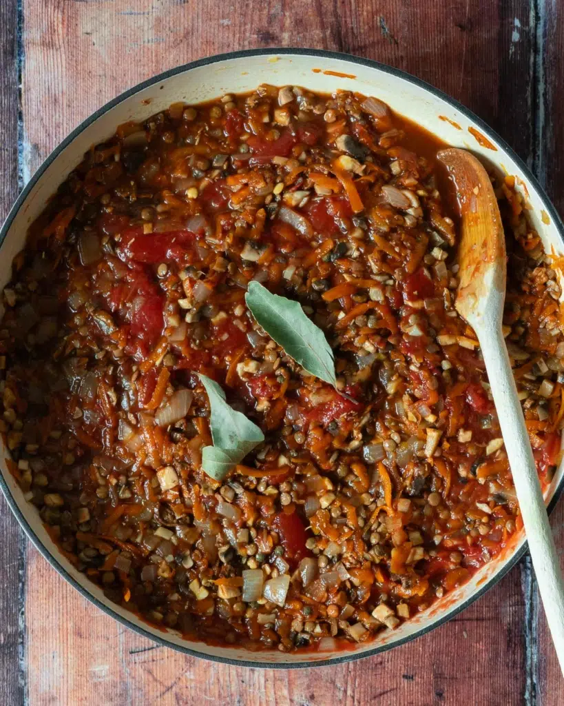 Vegan bolognese in a large frying pan, with two bay leaves on top