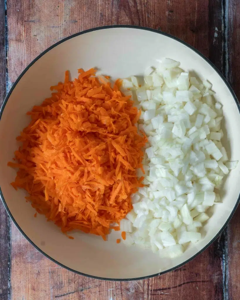 Diced onion and grated carrot in a large frying pan