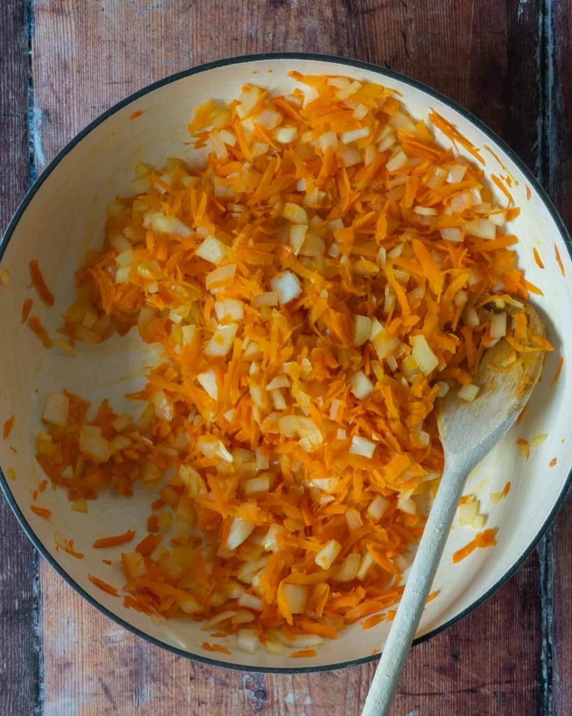 Diced onion and grated carrot in a large frying pan