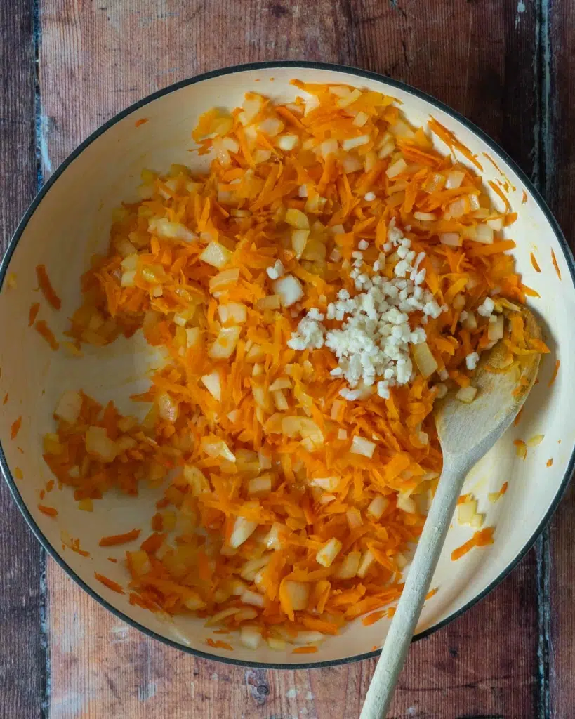 Diced onion, minced garlic and grated carrot in a large frying pan