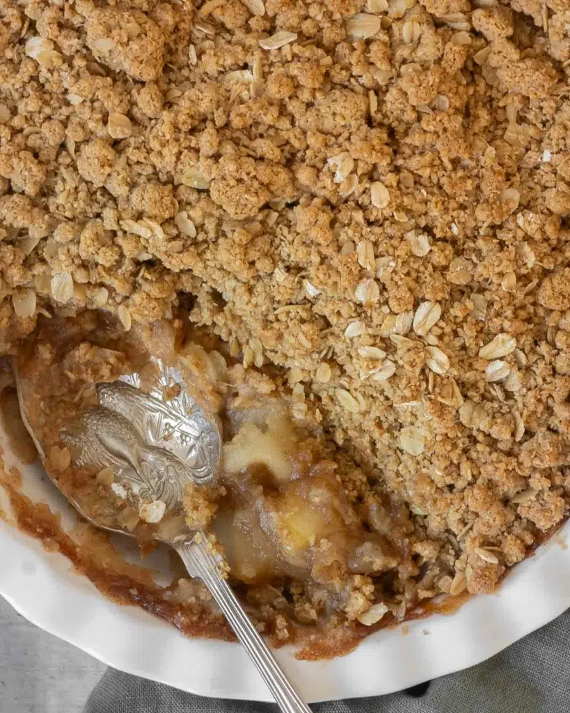 An overhead photograph of an apple crumble that has been topped with a crunchy oatmeal crumble topping.