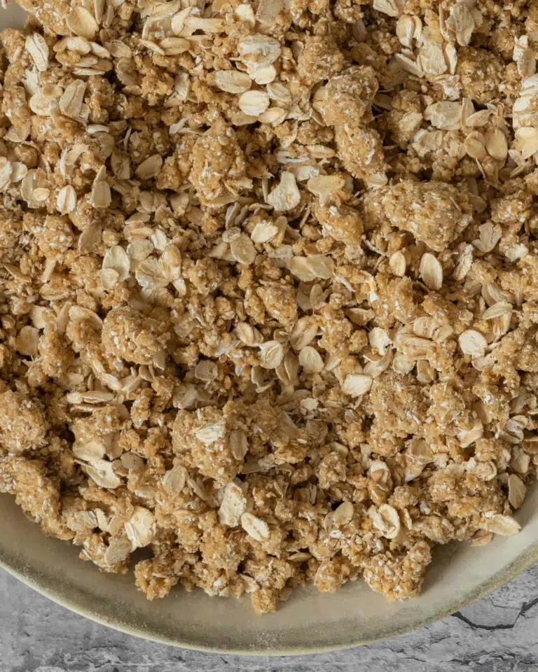 A close up photograph of freshly mixed oatmeal crumble topping, before it has been baked.