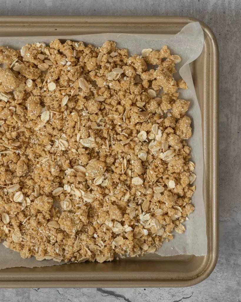 Oat streusel mixture on a baking tray ready to be put in the oven.