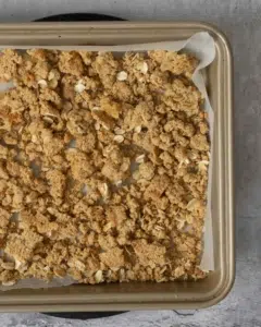 Golden, crunchy oat streusel crumble topping on a baking tray, fresh out of the oven.