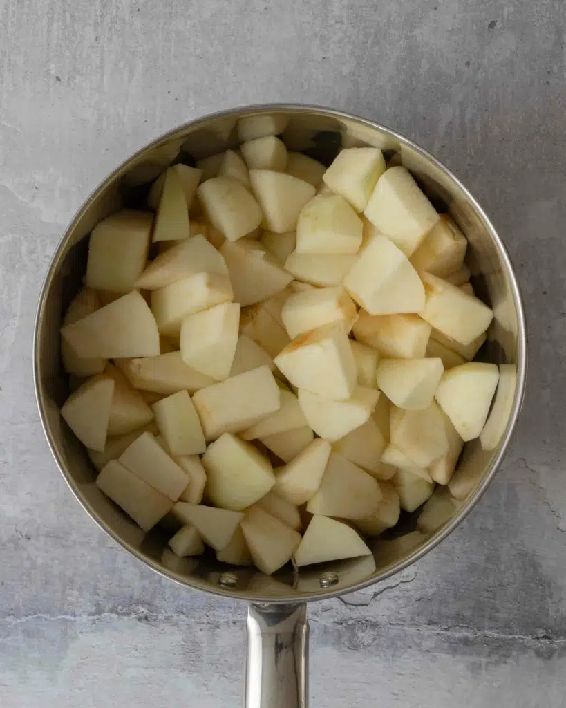 Raw apple peeled, cored and cut into chunks, in a saucepan