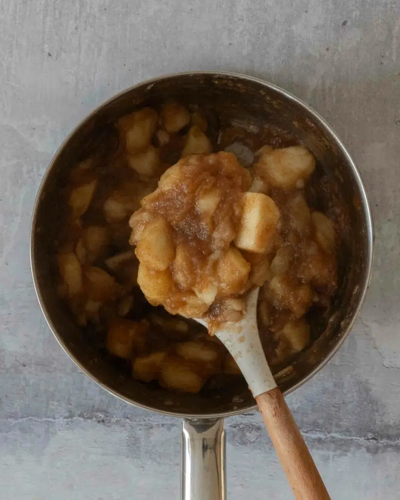 Stewed apple in a saucepan, a process shot for this vegan apple crumble recipe.